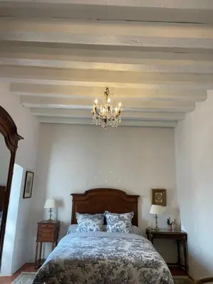 a bedroom with a bed with a chandelier at Domaine du Couvent de Saint Julien in Bonifacio