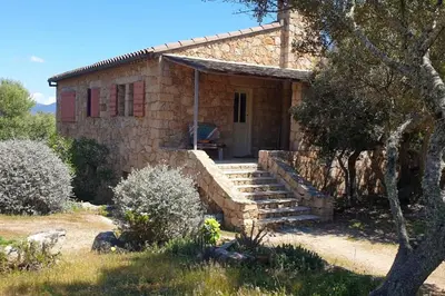 a stone house with a staircase in front of it at Tizzano, villa vue mer avec piscine in Sartène