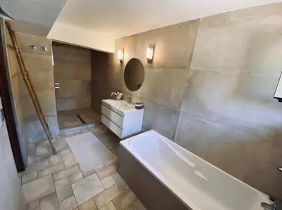 a bathroom with a tub and a sink and a mirror at Tizzano, villa vue mer avec piscine in Sartène