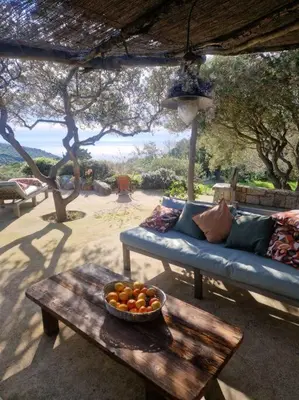 a blue couch and a bowl of fruit on a table at Tizzano, villa vue mer avec piscine in Sartène