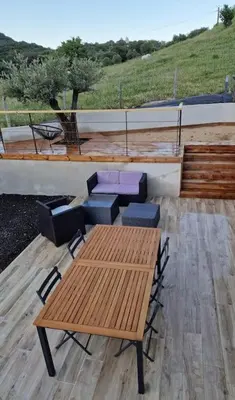 a wooden table and chairs sitting on a patio at Belle villa à la campagne dans un coin cosy in Sartène