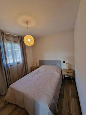 a bedroom with a large bed and a light at Belle villa à la campagne dans un coin cosy in Sartène