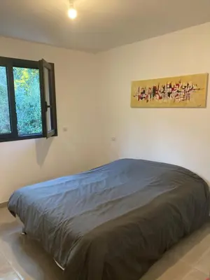 a bed in a bedroom with a painting on the wall at Villa 4 personnes - 2 chambres - Figari in Figari