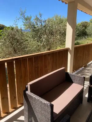 a patio with a couch and chairs on a porch at Villa 4 personnes - 2 chambres - Figari in Figari