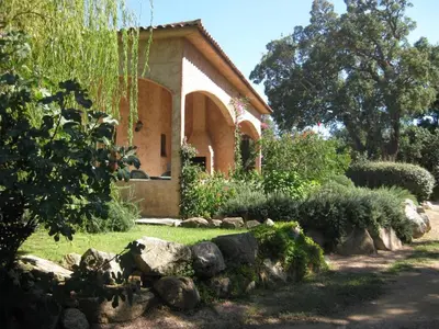 a house with a yard with rocks in front of it at Villa CASA CALLISTA , confort et calme in Sainte-Lucie de Porto-Vecchio