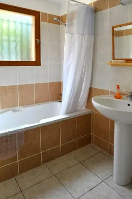a bathroom with a bath tub and a sink at Villa CASA CALLISTA , confort et calme in Sainte-Lucie de Porto-Vecchio