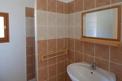 a bathroom with a toilet and a sink and a mirror at Villa CASA CALLISTA , confort et calme in Sainte-Lucie de Porto-Vecchio