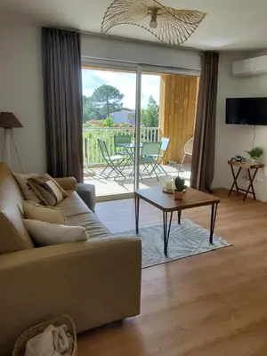 a living room with a couch and a table at Superbe T2 neuf 42m² Cala Rossa (proche mer) in Lecci