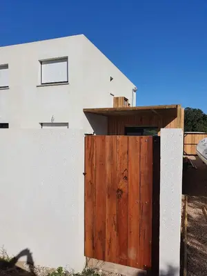 a white house with a wooden gate and a fence at Maison neuve Porto Vecchio in Porto-Vecchio