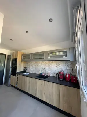 a kitchen with a black counter top with red appliances at Maison neuve Porto Vecchio in Porto-Vecchio