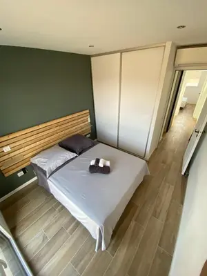 a bedroom with a bed with a wooden headboard at Maison neuve Porto Vecchio in Porto-Vecchio