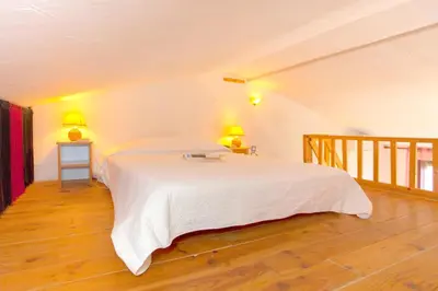 a kitchen with orange walls and a counter with pots and pans at Appartement charmant avec piscine à Porticcio - 32 m² in Porticcio