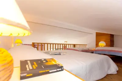a bedroom with two beds and a wooden staircase at Appartement charmant avec piscine à Porticcio - 32 m² in Porticcio