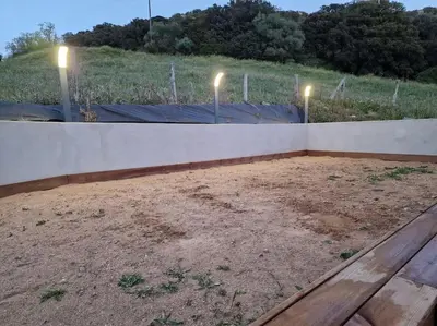 a concrete wall with lights on top of a field at Belle villa à la campagne dans un coin cosy in Sartène