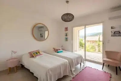 a white room with two beds and a window at VILLA MYRTE A CIRINDINU in Cirendinu