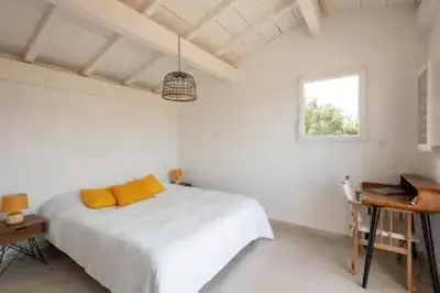 a white bedroom with a bed and a desk and a window at VILLA MYRTE A CIRINDINU in Cirendinu