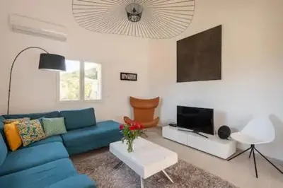 a living room with a blue couch and a tv at VILLA MYRTE A CIRINDINU in Cirendinu