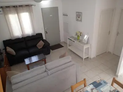a living room with a couch and a table at Villa climatisée T3 piscine chauffée accès direct à la plage de Prunete in Cervione