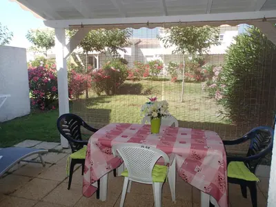 a table with a pink table cloth on a patio at Villa climatisée T3 piscine chauffée accès direct à la plage de Prunete in Cervione