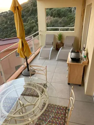 a room with a glass table and chairs on a balcony at ajaccio Sanguinaires in Ajaccio
