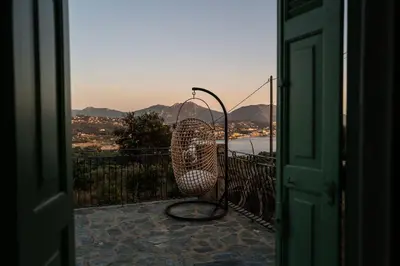 a wicker chair sitting on top of a balcony at VILLA A MUREDDA, piscine chauffée et vue mer in Olmeto