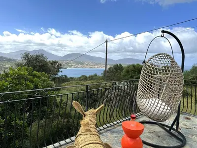 a llama sitting on a balcony looking at the water at VILLA A MUREDDA, piscine chauffée et vue mer in Olmeto