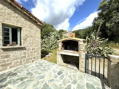 an outdoor pizza oven in a stone building at VILLA A MUREDDA, piscine chauffée et vue mer in Olmeto