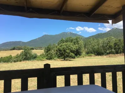 a view from a porch with mountains in the background at PROCHE du PONT GENOIS in Sartène