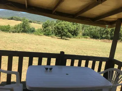 a white table and chairs on a porch with a field at PROCHE du PONT GENOIS in Sartène