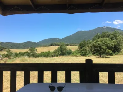 a view from a porch with a table and sunglasses at PROCHE du PONT GENOIS in Sartène