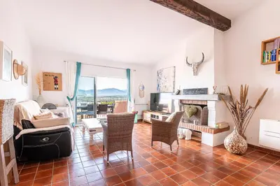 a living room with a table and chairs and a fireplace at Terra Di Sole - Vue mer et montagne in Grosseto-Prugna