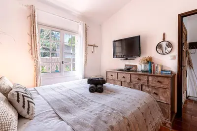a bedroom with a bed with a television on a dresser at Terra Di Sole - Vue mer et montagne in Grosseto-Prugna