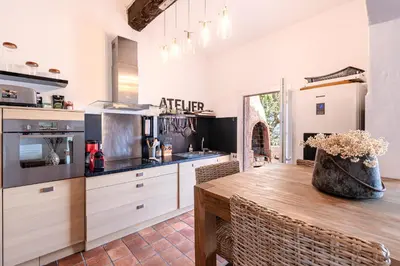 a large kitchen with a wooden table and chairs at Terra Di Sole - Vue mer et montagne in Grosseto-Prugna