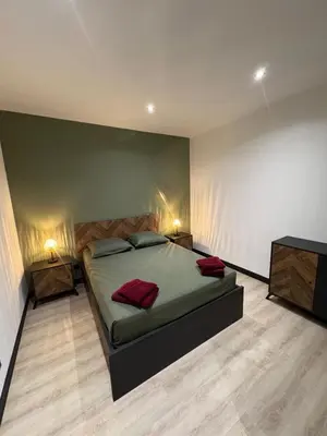 a bedroom with a bed with two night stands and two lamps at T3 - 100m du port in Propriano