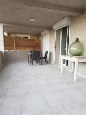 a patio with a table and chairs and a green bowl at Maison T2 500m de la plage in Poggio-Mezzana