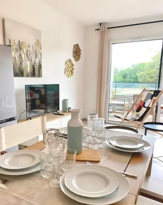 a kitchen with a refrigerator and a table and chairs at L'Ondella T2 Porticcio et Garage in Porticcio