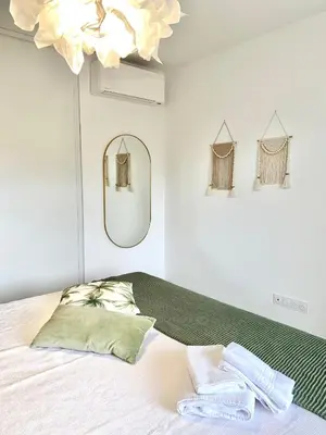 a bedroom with a white bed with two green pillows at L'Ondella T2 Porticcio et Garage in Porticcio