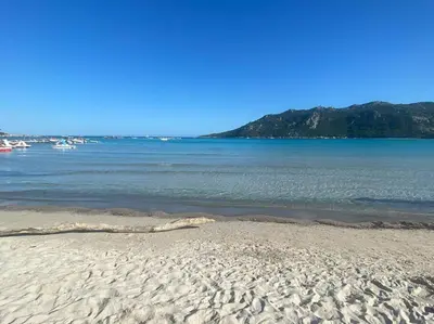 a sandy beach with boats in the water at Appartement 4 personnes - Grande terrasse - Proche du Port - Porto-Vecchio in Porto-Vecchio