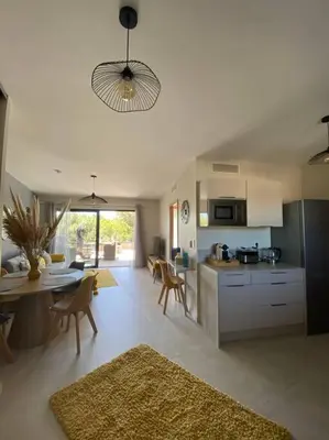 a kitchen and living room with a table and chairs at Appartement 4 personnes - Grande terrasse - Proche du Port - Porto-Vecchio in Porto-Vecchio