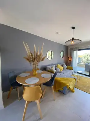 a living room with a table and a bed at Appartement 4 personnes - Grande terrasse - Proche du Port - Porto-Vecchio in Porto-Vecchio