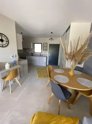 a kitchen and dining room with a table and chairs at Appartement 4 personnes - Grande terrasse - Proche du Port - Porto-Vecchio in Porto-Vecchio
