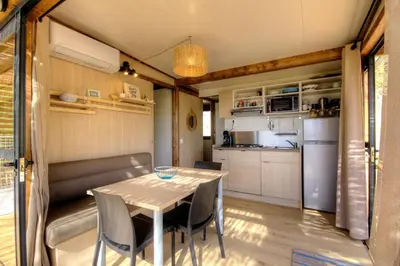 a kitchen and dining room with a table and chairs at Chalet U Pinu in Venaco