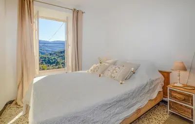 a bedroom with a large bed and a window at Awesome Home In San-Gavino Di Carbini in San-Gavino-di-Carbini