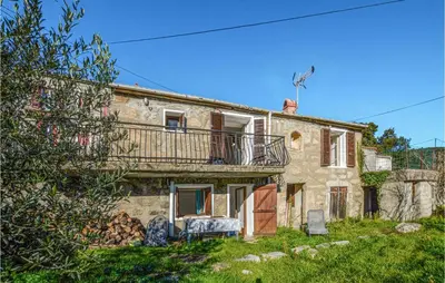 an old stone house with a balcony on it at Awesome Home In San-Gavino Di Carbini in San-Gavino-di-Carbini
