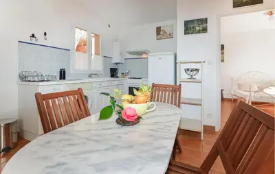 a kitchen with a table with a vase of flowers on it at Stunning Home In Afa With Wifi in Afa