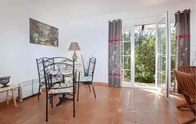a living room with a table and chairs and windows at Stunning Home In Afa With Wifi in Afa