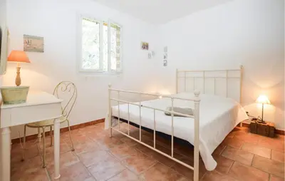 a bedroom with a bed and a desk and a table at Cozy Home In Piscia Rossa With Wifi in Afa