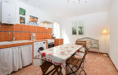 a kitchen with a table and a washing machine at Cozy Home In Piscia Rossa With Wifi in Afa