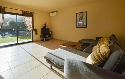 a living room with a couch and a tv at Nice Home In Sagone With Wi-Fi in Sagone