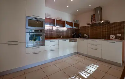 a kitchen with white cabinets and white appliances at Nice Home In Sagone With Wi-Fi in Sagone